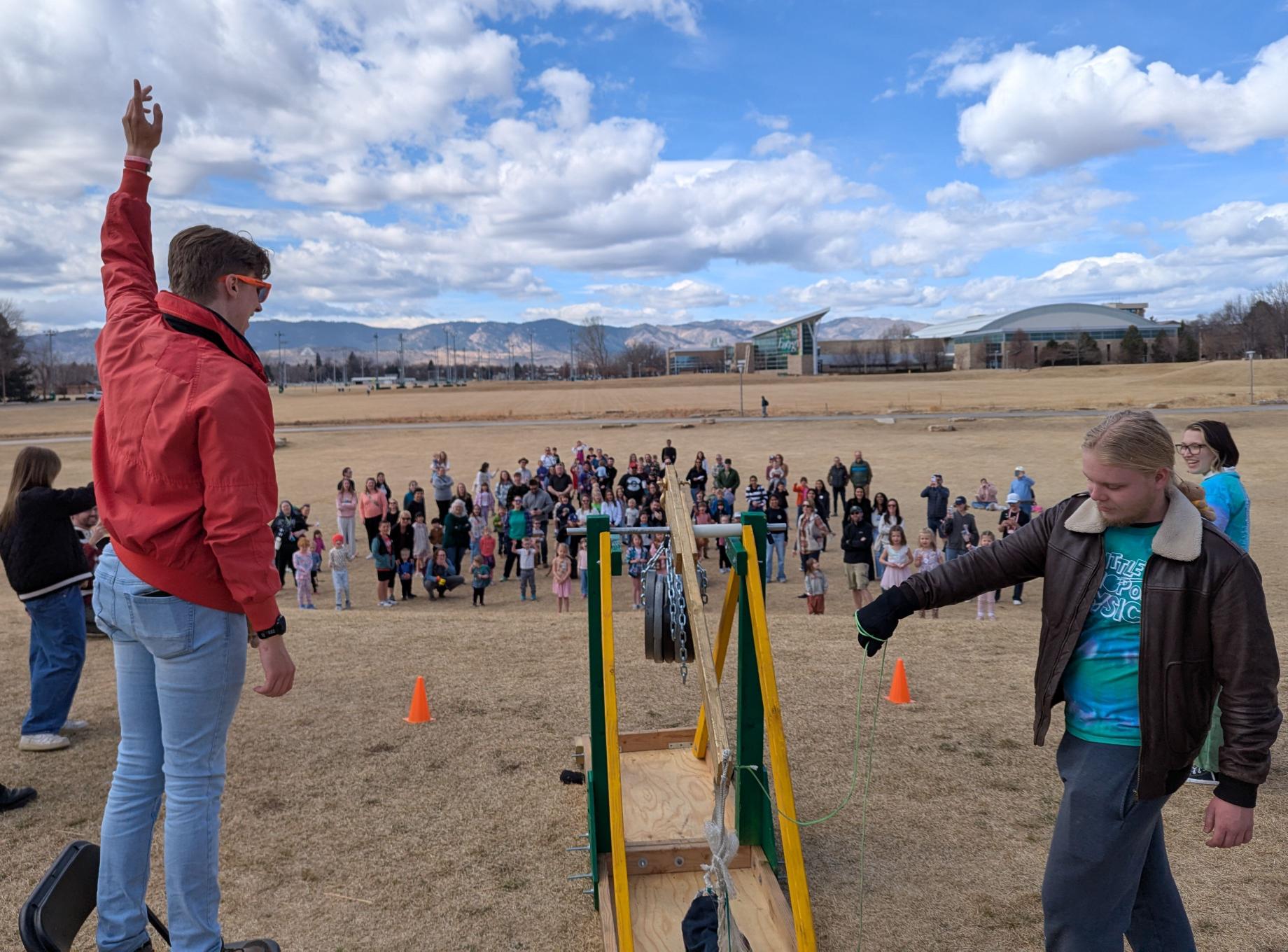Former Science Officer, Michael, and Communications Officer, Tripp, use the trebuchet to launch teddy bears at the Little Shop of Physics Open House 2026