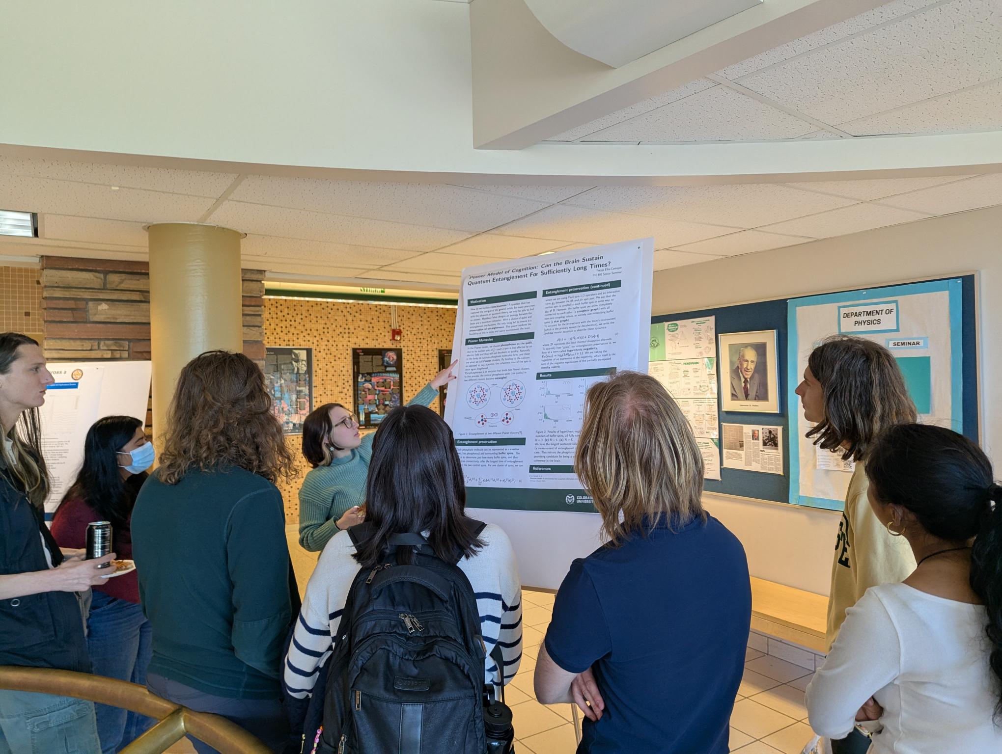 Former Vice President Freyja presenting her senior seminar poster to members of SPS at our annual poster session
